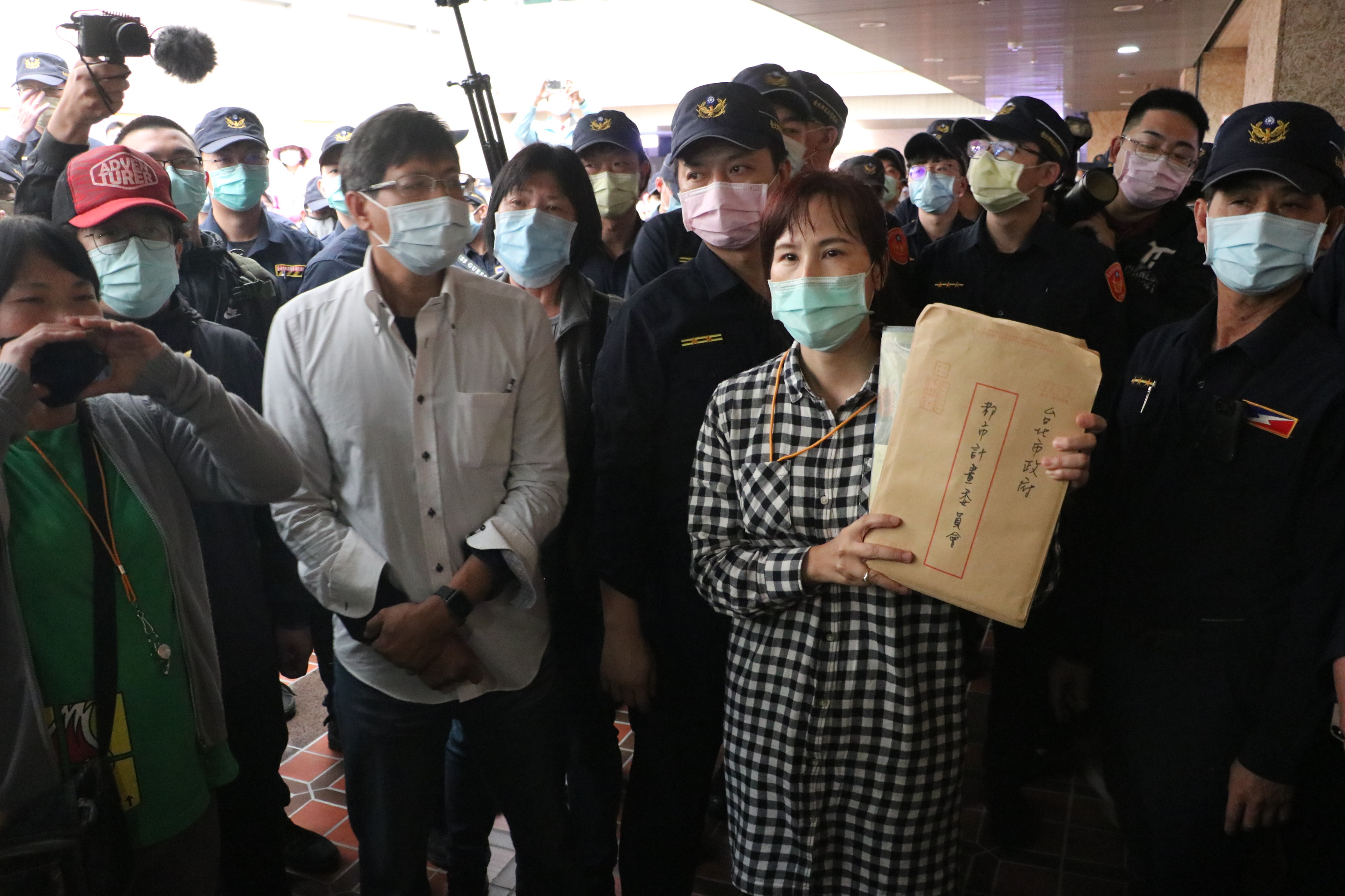 社子島自救會發言人李華萍手持居民陳情書欲進入會場遞交給都委會委員